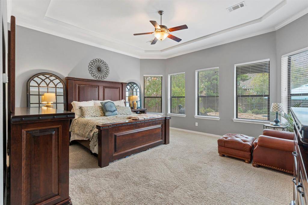 Spacious primary bedroom with tray ceiling and amazing views of the backyard.