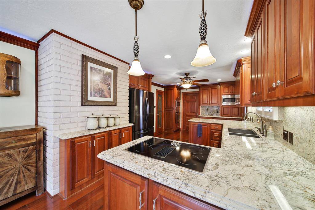 Beautiful pendant lighting above the cooktop - LOVE the brick accent wall! Oven and second microwave located to the right of the refrigerator.