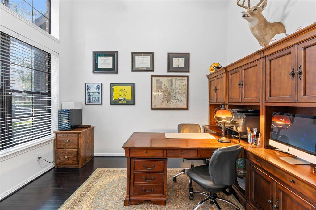 Private home office with wood floors and high ceilings.