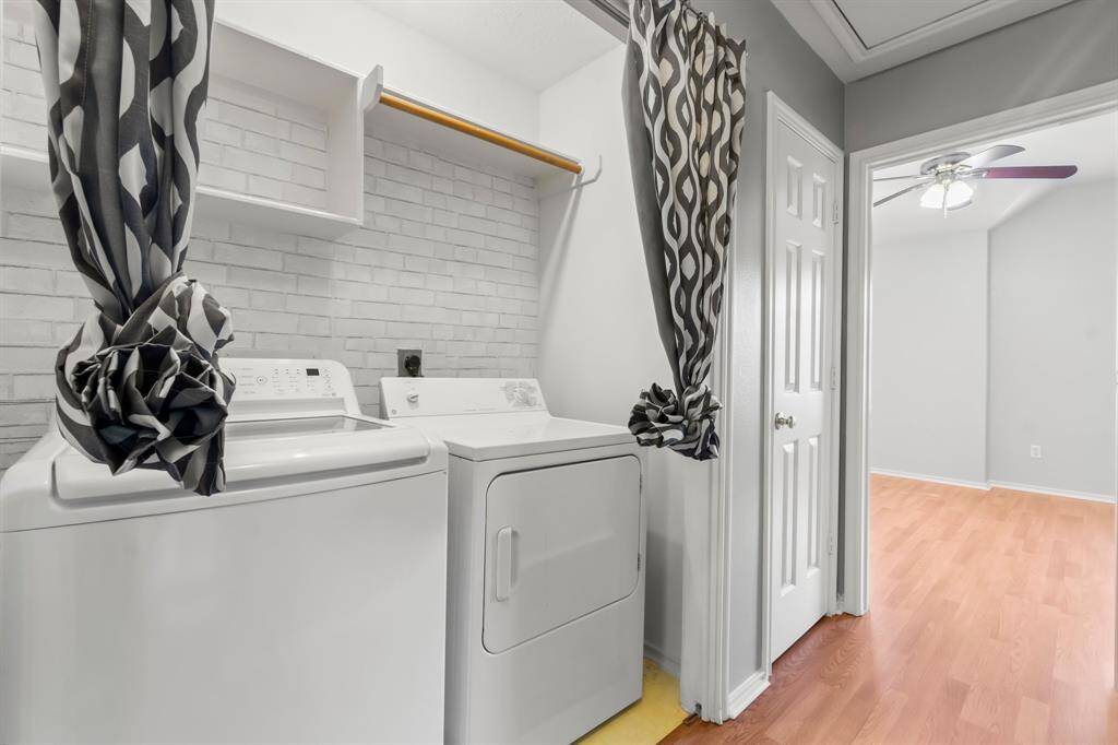 This spacious Master bedroom features light floors, neutral walls, and a ceiling fan. It includes a walk in closet and an en-suite bathroom with a modern vanity.