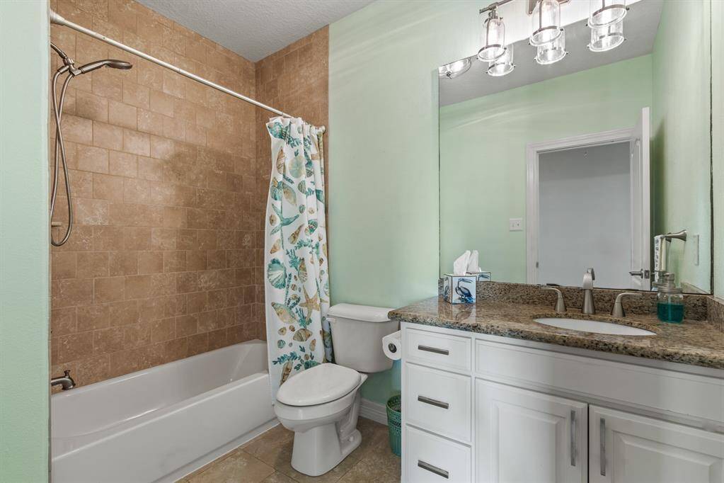 Secondary bathroom with neutral tub and tile combination.