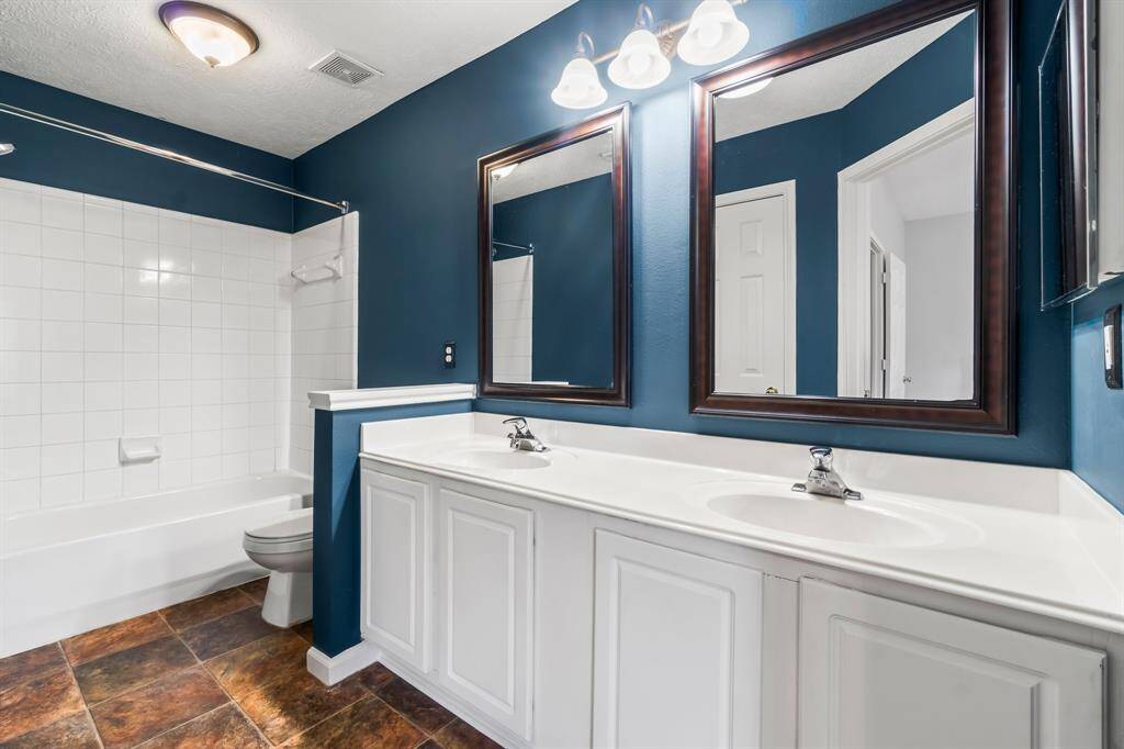 This photo shows a spacious walk-in closet with white walls, multiple shelves, and ample hanging space, ideal for organizing clothes and accessories.