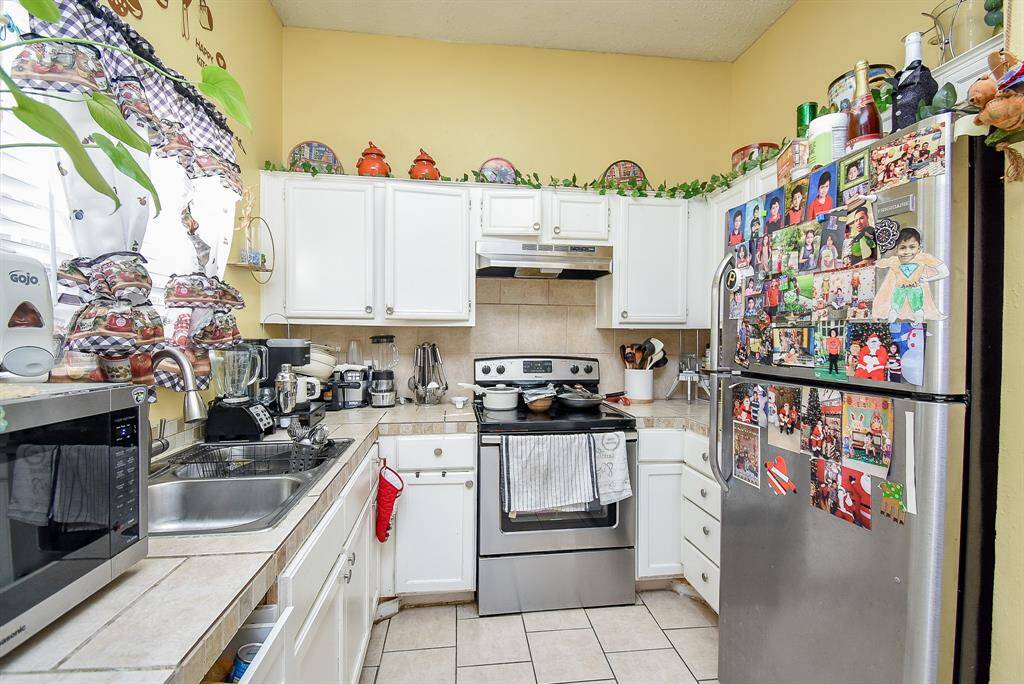 Stainless steel appliances add to the glow and workability of this bright kitchen.