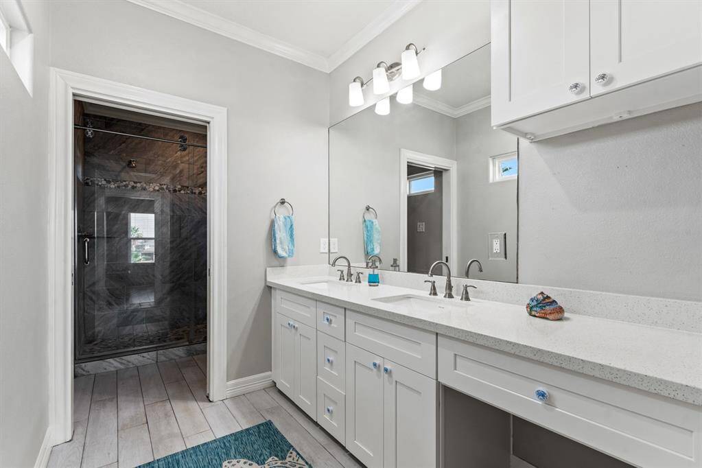 Primary bath offers quartzite countertops, ample storage and double sinks.