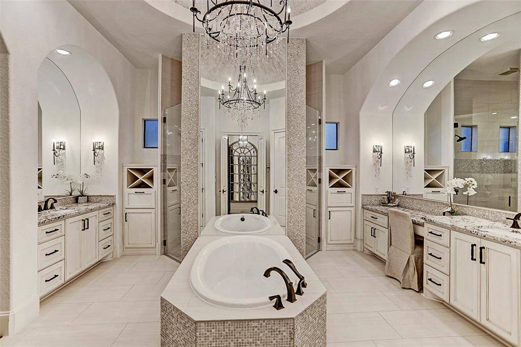 Master Bath | Luxury at its finest! This opulent spa bath with a glass-enclosed shower, custom chandelier, beautiful granite, and magnificent tub mimics the luxury and attention to detail found throughout the rest of this home