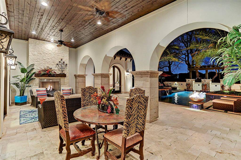 Covered Patio | The irresistible covered patio graced by a stacked stone fireplace is truly amazing and boasts gorgeous canterra arches leading to your backyard