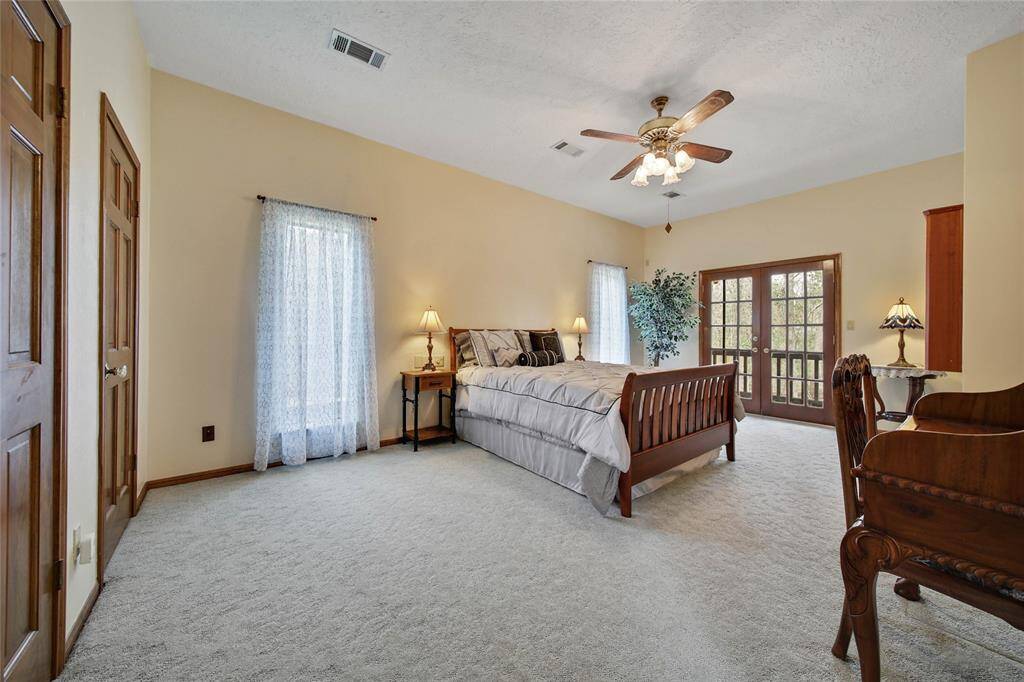 HUGE bedroom in this guest house! Ample space to add a desk/work area - I told you they won't leave! Another double French door access to the wrap around balcony area. Full bath with large shower off bedroom.