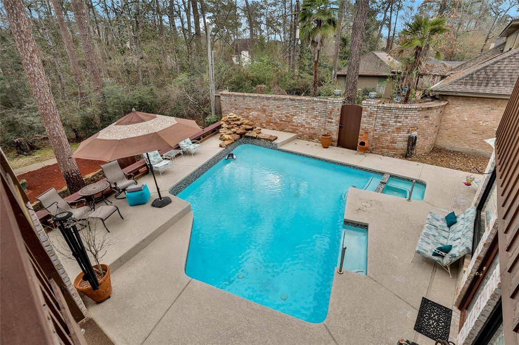View from above off the owner's upstairs patio! This is a 25k pool with multi colored lighting. Saltwater filtration system and Pentair gas heater for pool; Set of white metal pool furniture included!
