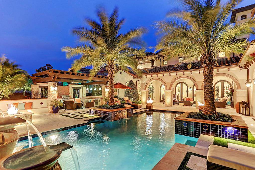 Tropical Backyard Paradise | The custom water features and beautiful back elevation just adds to the ultimate entertainment and relaxation of this home