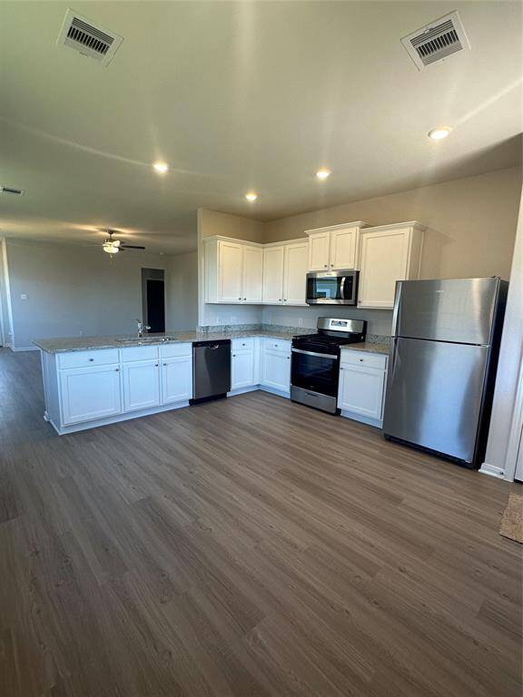 Equipped with high-quality Whirlpool appliances, including a refrigerator, stove, and dishwasher, and complemented by elegant granite countertops, this kitchen combines both style and functionality, perfect for cooking and entertaining.