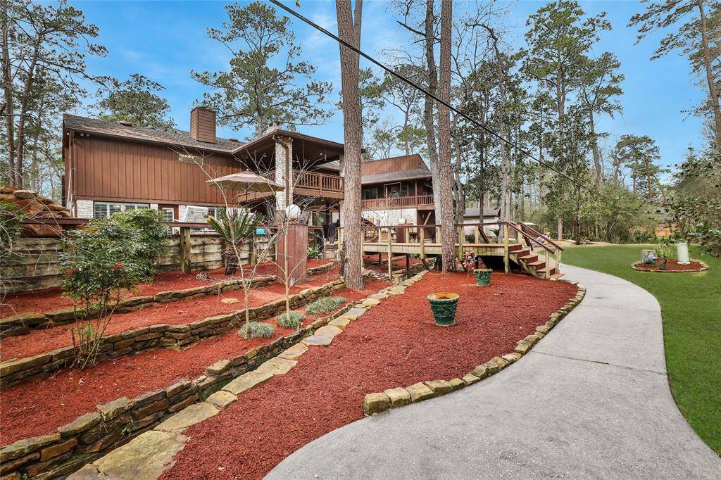 Rear property view - this property is high and dry! Love the multiple levels of landscaping - such personality! This little area could fit a nice sized table/chairs for a little separation!
