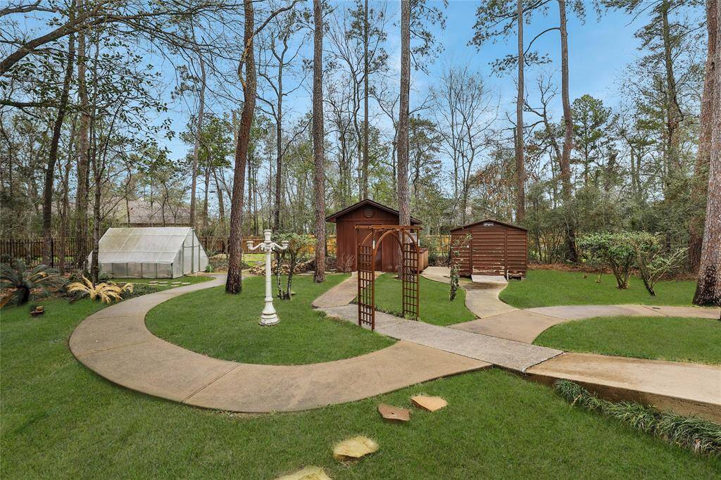 Located to the left of the property the concrete paths continue! You have a green house for my gardeners with supplied watering system, storage building with wall to wall pegboards and golf cart storage or hobby building! Lawn has 12 zone B-Hyve wifi controlled sprinkler system and 4 zone Rainbird system for north section of yard.
