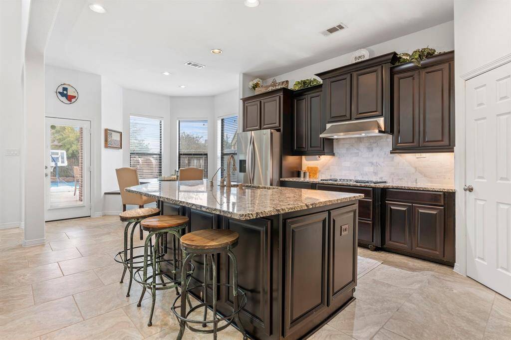Sun filled kitchen and breakfast area. Large sink in island with filtered water dispenser.