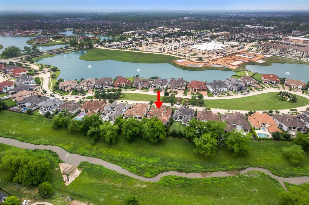 The Aerial view showcases the Beautiful Lake and Ravine with lush trees behind the home.