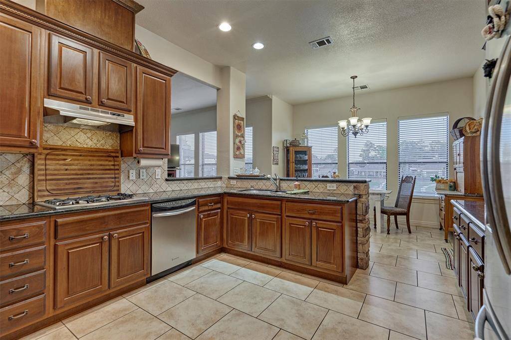 The kitchen features a gas cooktop and rich, stained wood cabinetry, combining style and functionality for the home chef.