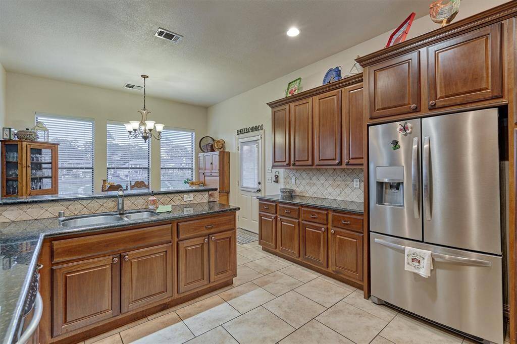 This kitchen offers an abundance of cabinetry and generous counter space, providing ample room for storage, meal prep, and entertaining.