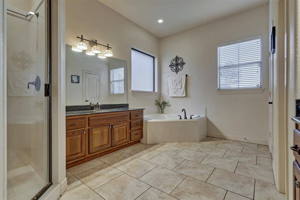 The primary bath also includes a separate shower and a generously sized area for getting ready, combining comfort and functionality in a well-designed space.