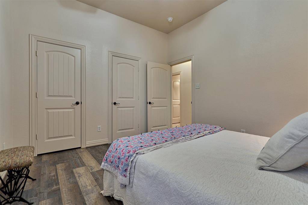 This bedroom offers two closets that connect behind the wall, forming one expansive storage space. A full bath is located just across the hall for added convenience.