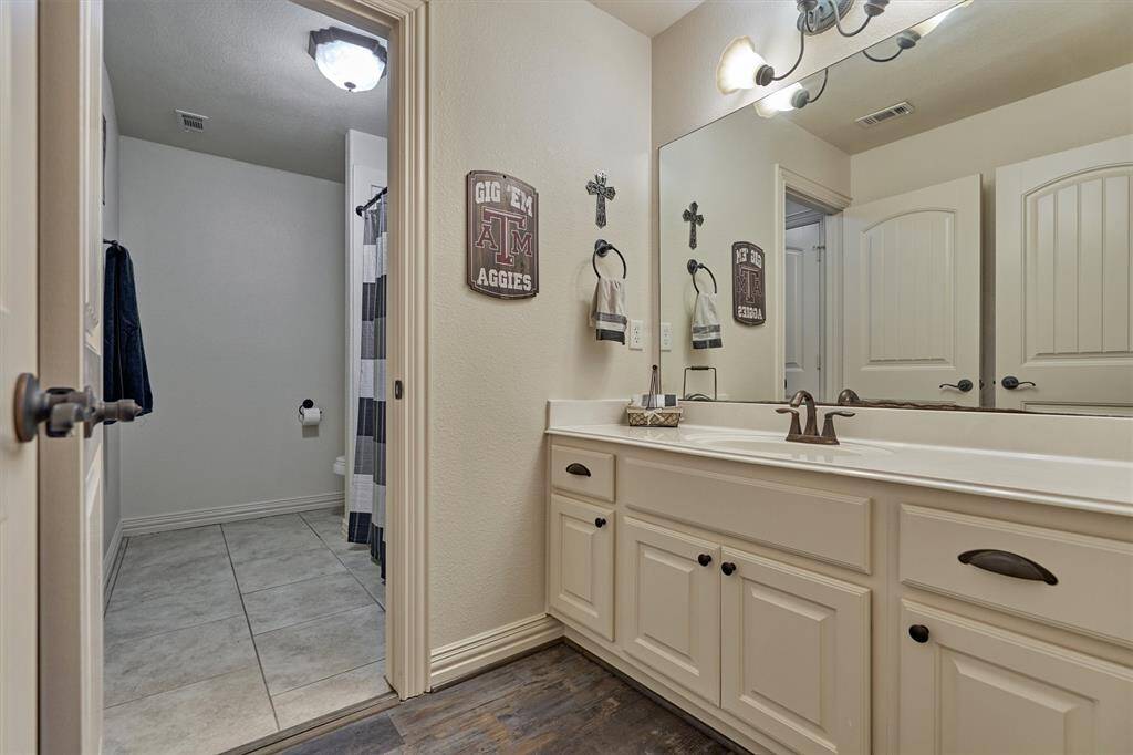 A second sink and vanity area is located off the hallway, directly across from the fourth bedroom.