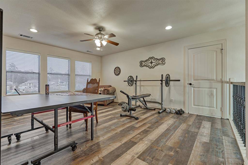 The spacious game room features large windows with scenic lake views and includes convenient access to a walk-in attic space—perfect for extra storage space.