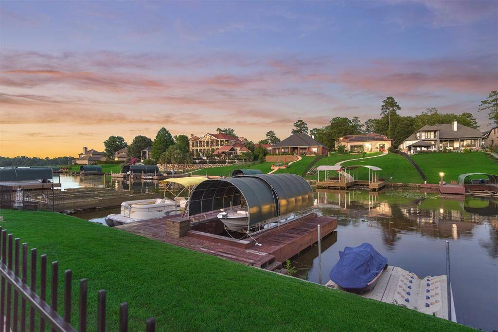 The boat dock features convenient steps leading down to the lake, while the floating jet ski lifts rise and fall with Lake Conroe’s changing water levels—offering easy access and added peace of mind.