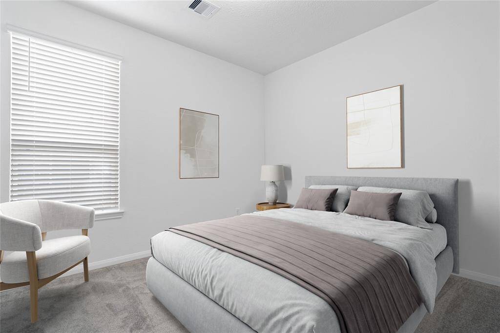 Secondary bedroom features plush carpet, custom paint, large window with privacy blinds and ample closet space.
