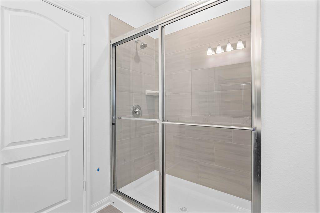 This primary bathroom features an oversized walk-in shower with tile surround.