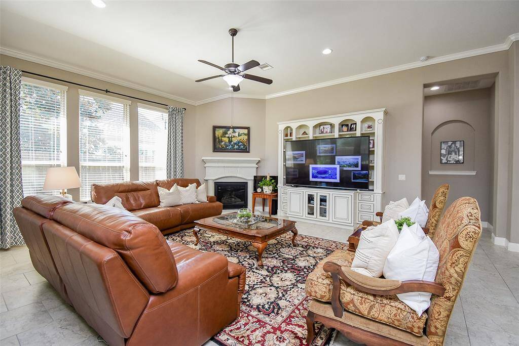 Living room with built-in cabinetry, gas log fireplace and walls of windows for a light, fresh environment.