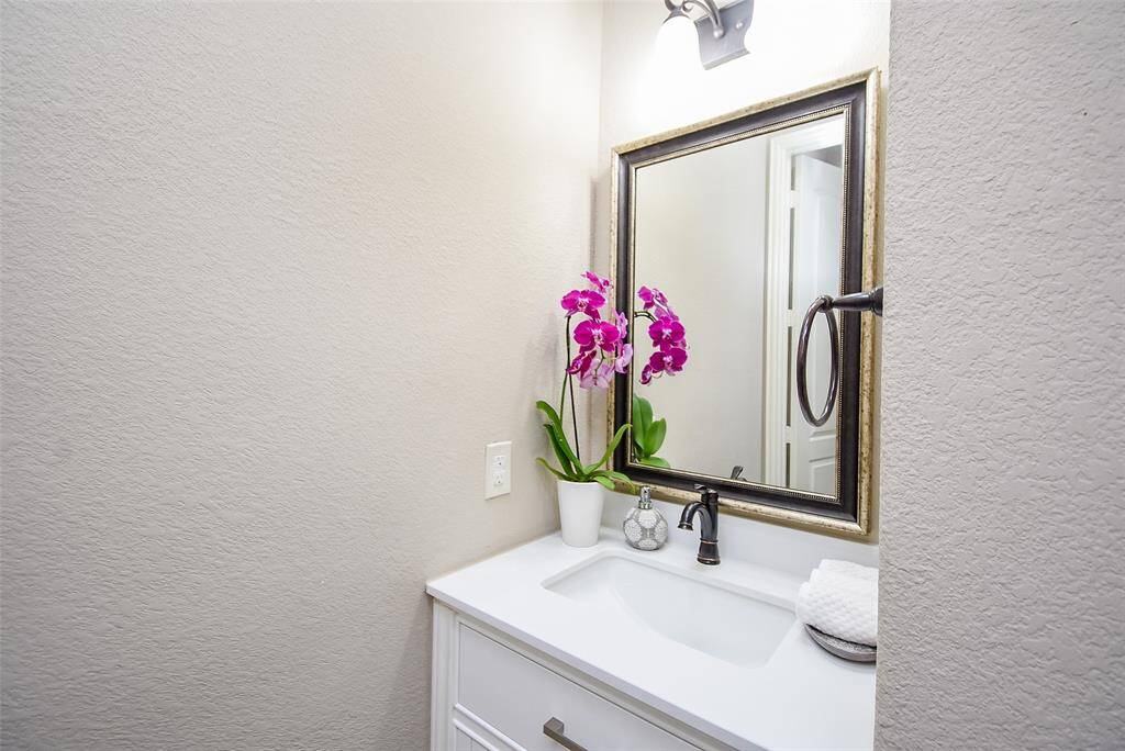 Powder room bath tucked neatly at the garage entry hallway with updated vanity.