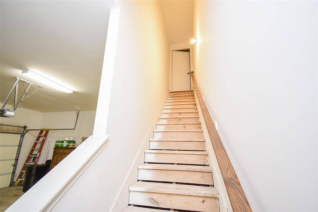 Staircase with handrail to your oversized, floored attic space for easy maintenance of your home's HVAC and hot water heater system.