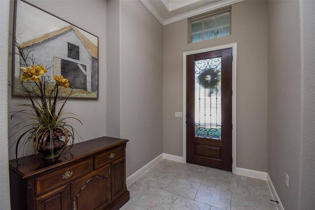 Iron detailed front door leads to your extended entry foyer.