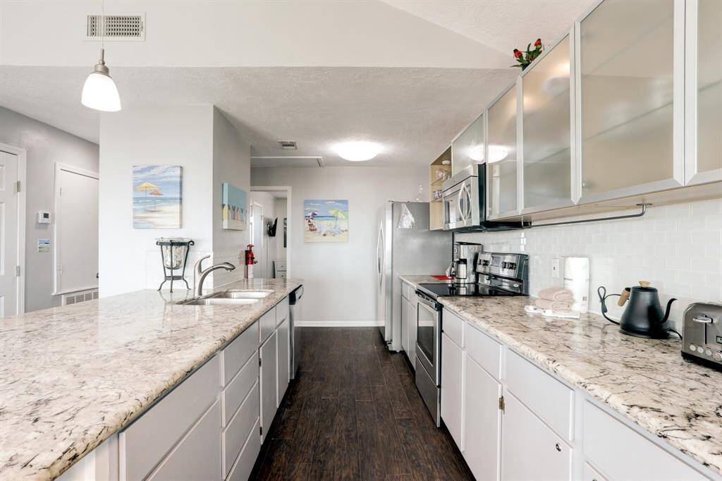KITCHEN FEATURES UPDATED STAINLESS STEEL APPLIANCES, GORGEOUS COUNTERS AND GLASS FRONT CABINETS.