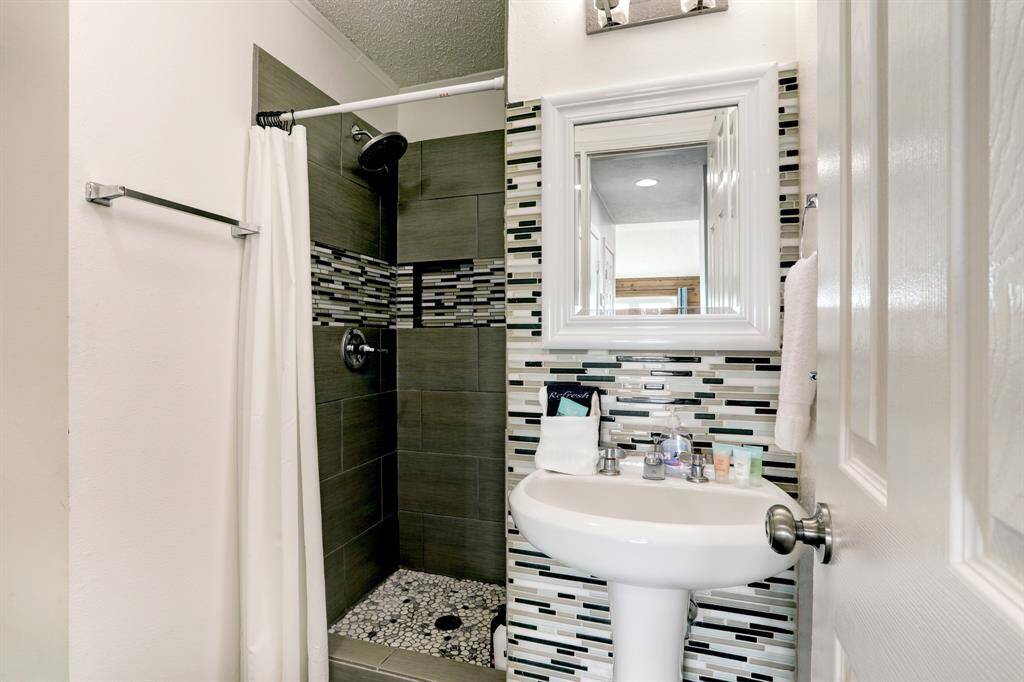 PRIMARY BATHROOM OFFERS A WALK-IN SHOWER WITH CUSTOM TILE WORK.