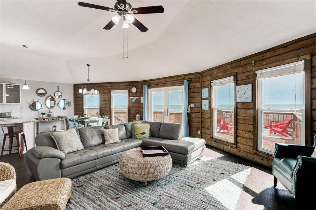 ANOTHER VIEW OF THE LIGHT AND BRIGHT LIVING ROOM THAT OFFERS A CAPTIVATING BEACH SCENERY.