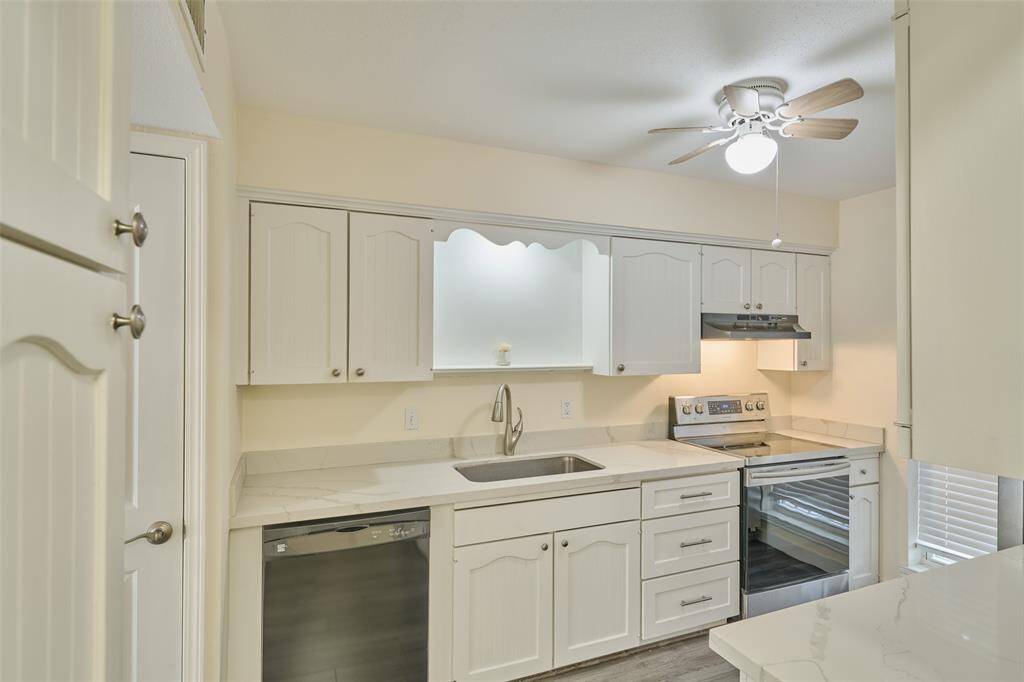 Bright and inviting kitchen with white cabinetry, modern appliances, and ample counter space.
