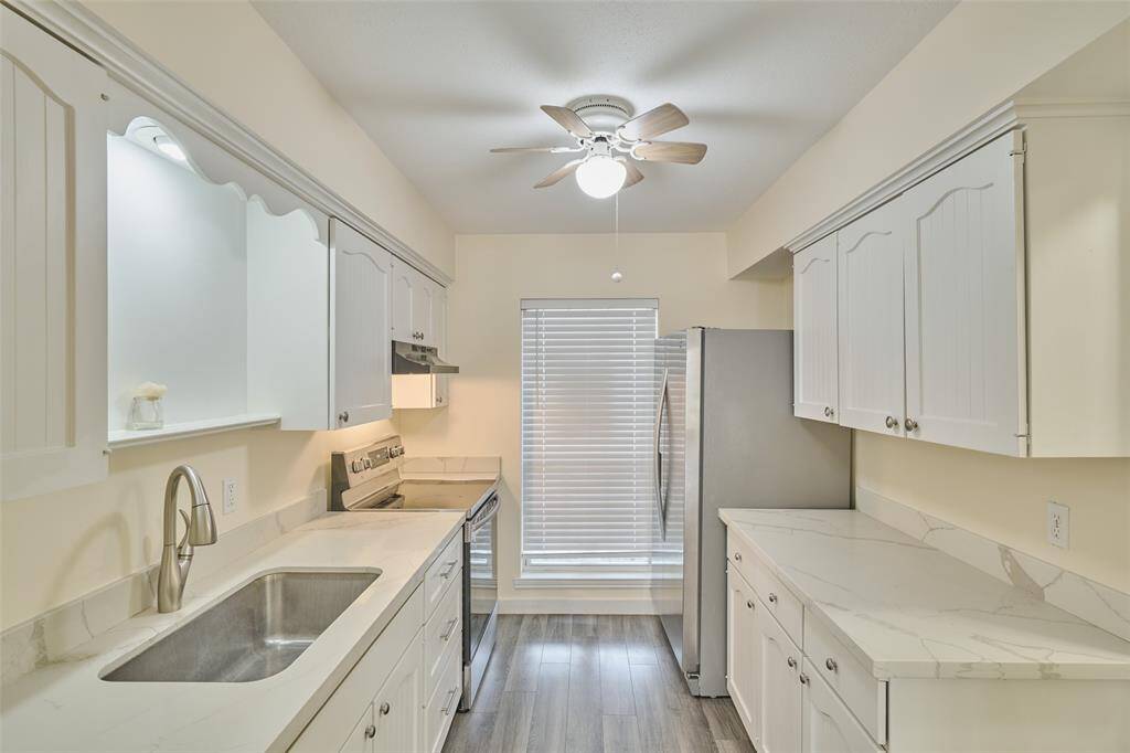 Modern kitchen with sleek countertops, ample cabinet space, and stainless steel appliances.