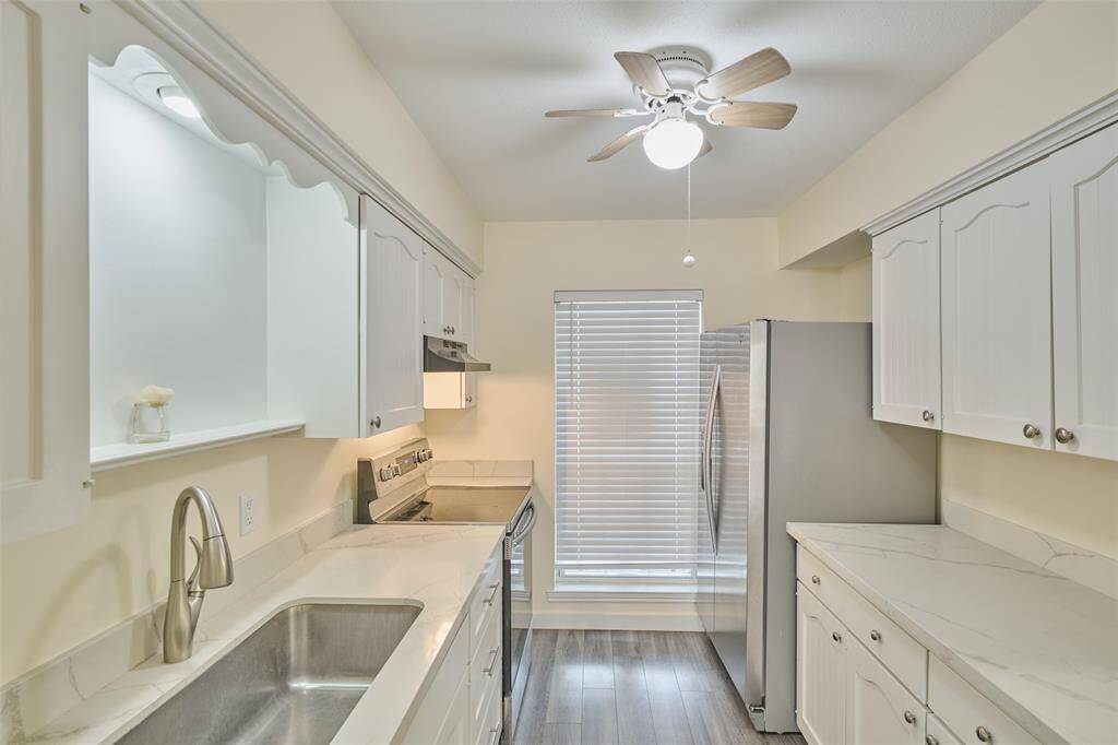 Modern kitchen featuring sleek cabinetry, marble countertops, and stainless steel appliances.