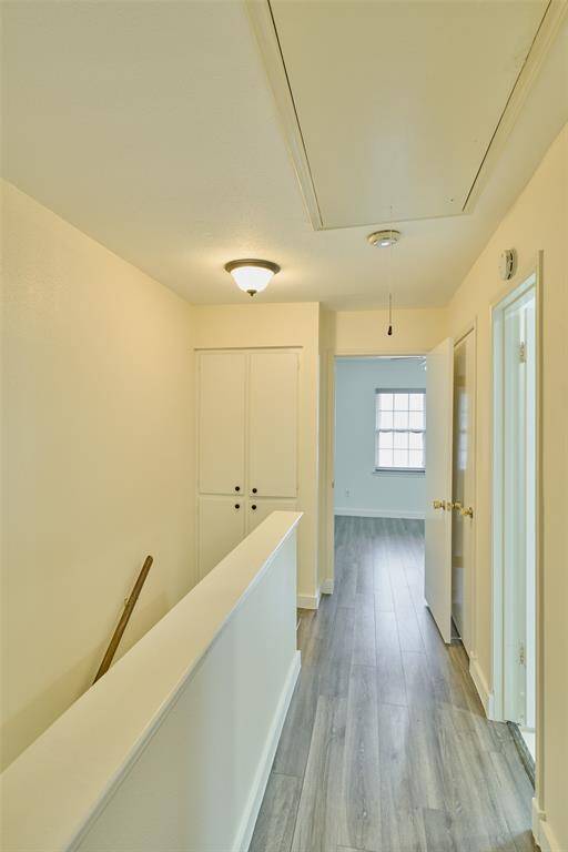 Spacious second-floor hallway with elegant flooring and ample natural light.