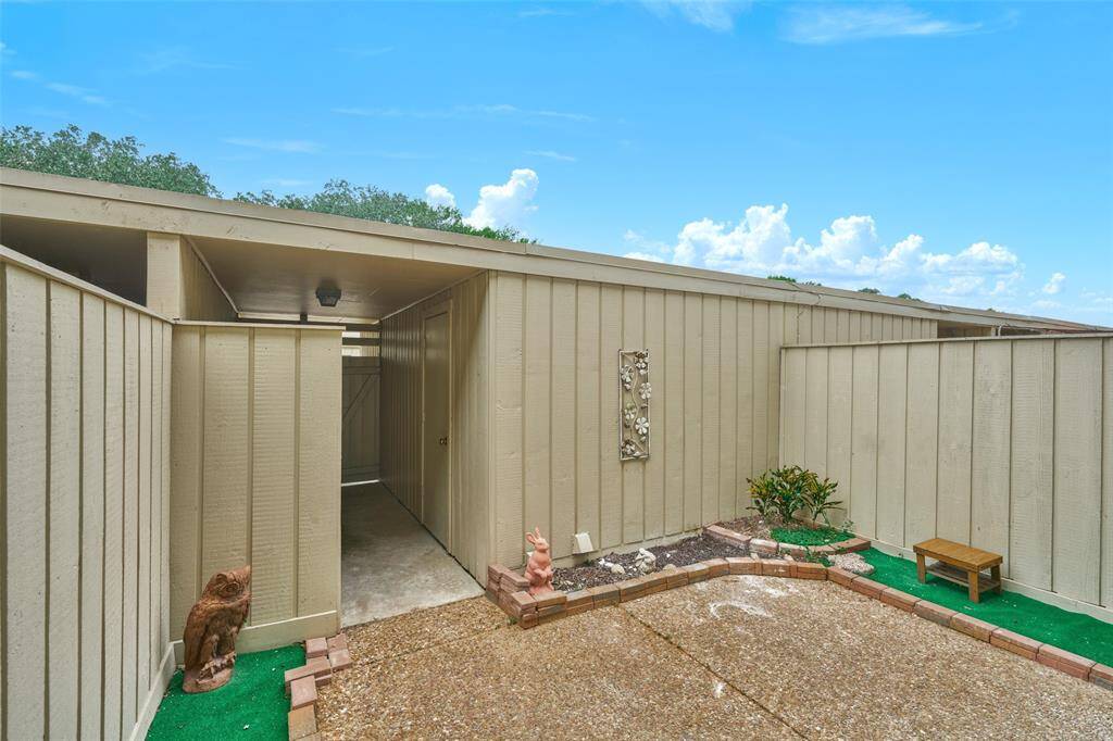 Experience ultimate privacy and security with this home's secluded entrance walkway, enhanced by charming decorative touches and a quaint garden space.