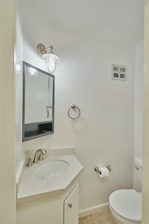 Discover this stylish half-bath featuring a sleek pedestal sink, modern faucet, and mirrored medicine cabinet. Brightly lit with a chic sconce and neutral walls, it's both functional and elegant.