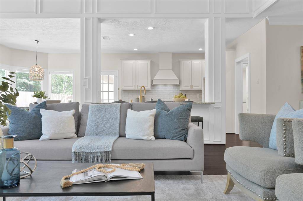 An effortless connection between living and culinary spaces—offering a glimpse of the light-filled, designer kitchen just beyond the elegant columns.