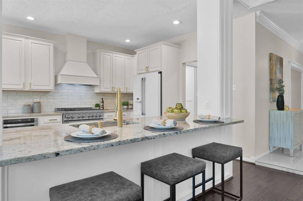 he heart of the home—this designer kitchen features quartz countertops, custom cabinetry, and a spacious island with counter seating, all crafted for both style and function.