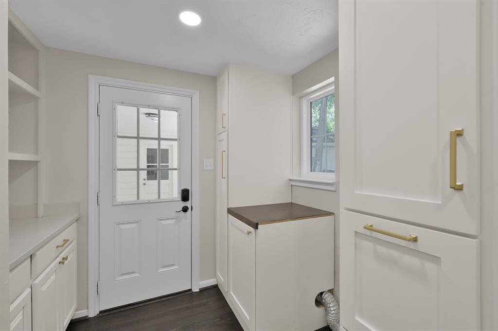 This thoughtfully designed utility room offers abundant cabinetry, a built-in folding station, and backyard access—delivering both elegance and efficiency in a high-traffic space.