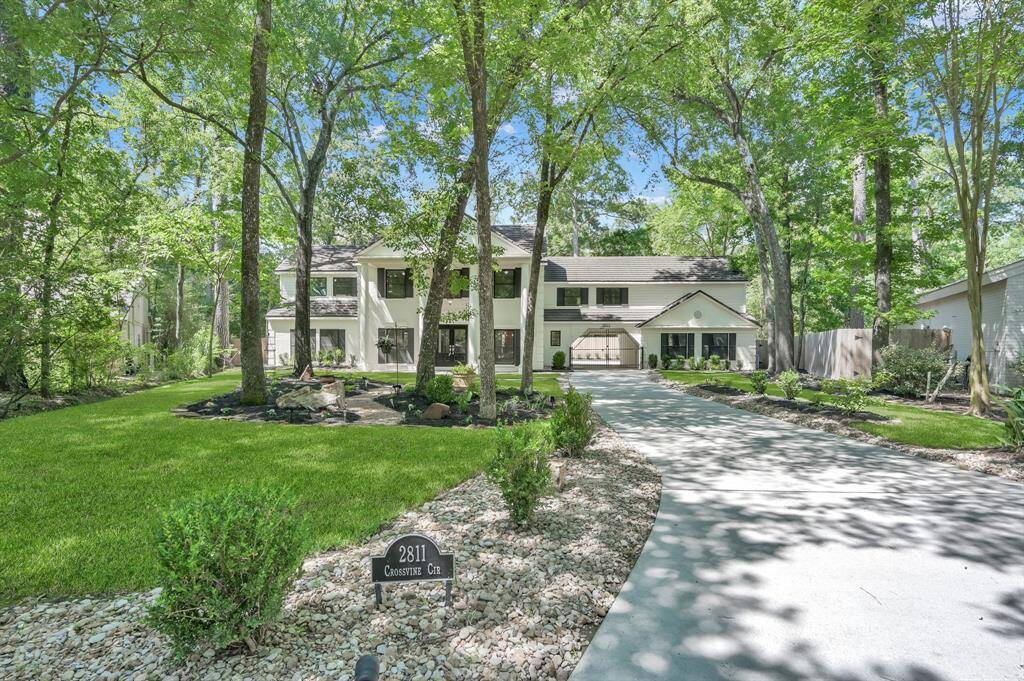 Nestled beneath a canopy of mature trees, this stately estate offers unparalleled privacy and curb appeal—welcoming you home with timeless Southern charm and serene wooded surroundings.