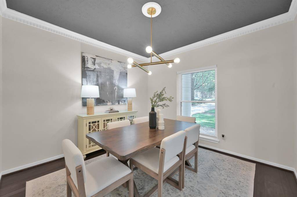 An elegant dining space defined by sleek contrast—featuring a dramatic painted ceiling, statement lighting, and sophisticated natural light for unforgettable gatherings