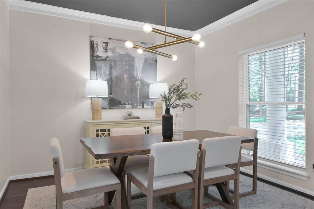 Bold and refined, the formal dining room showcases a dramatic painted ceiling, contemporary lighting, and elegant millwork—creating a striking space for elevated entertaining.