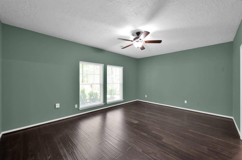 The primary suite offers a private retreat with tranquil green tones, large-scale windows, and ample space for a king-sized layout—setting the stage for comfort, elegance, and restful living.