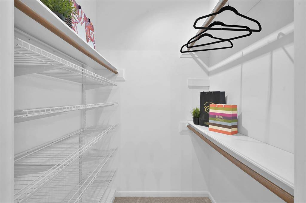 The expansive walk-in closet offers custom built-ins and ample hanging space—designed to keep wardrobes beautifully organized in the primary suite.