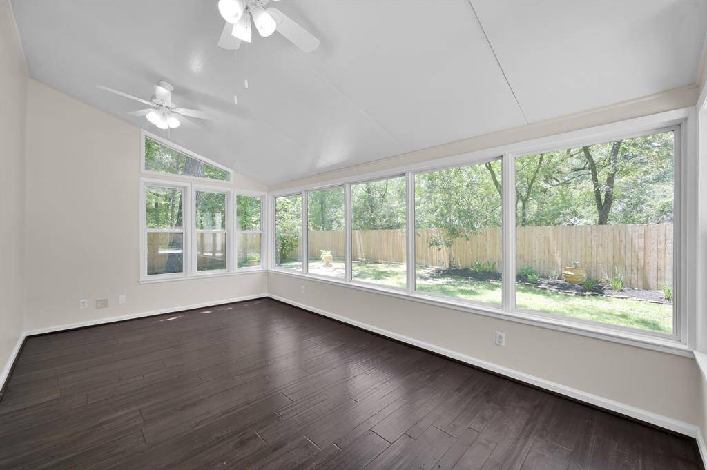 Wrapped in windows, this sunroom offers panoramic backyard views and endless versatility—ideal for a serene lounge, playroom, or indoor garden escape.