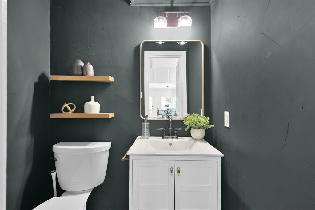 A bold powder bath with moody tones, floating wood shelves, and a sleek vanity—perfectly blending modern edge with everyday elegance.